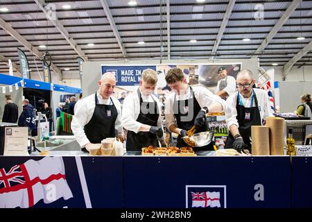 Gli chef della Royal Navy cucinano dal vivo alla fiera Source Food, drink, catering e ospitalità che si tiene a Westpoint Exeter Regno Unito, con espositori e marchi il 7 febbraio 2024 Foto Stock