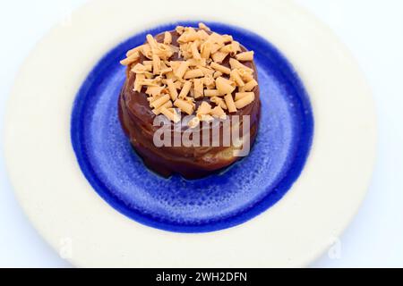 Una torta di toffee su un piatto bianco e blu vibrante. Foto Stock