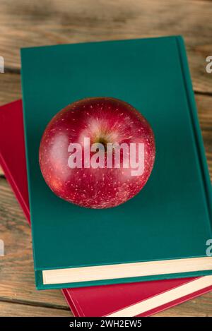 Vista dall'alto di una mela rossa stesa su libri con copertina rigida. Concetto di conoscenza. Foto Stock