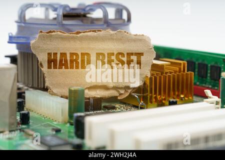 Sulla scheda madre del computer è presente un cartone con la scritta "hard reset". Concetto di computer. Foto Stock