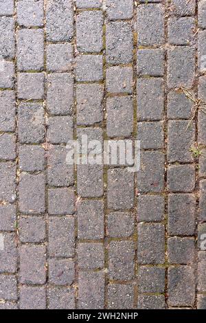 Consistenza del marciapiede con pietre rossastre quadrate ruvide. Foto Stock