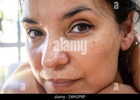 Foto molto ravvicinata di una donna latina naturale con trucco permanente sulle palpebre. Foto Stock