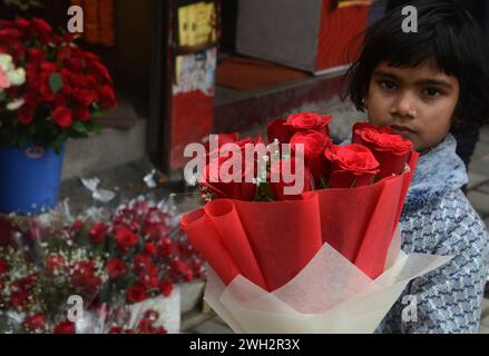 Silguri, Bengala Occidentale, INDIA. 7 febbraio 2024. Un figlio di fiori di un venditore detiene un mazzo di rose mentre suo padre organizza la vendita ai clienti al mercato dei fiori di Siliguri il 7 febbraio 2024. Le rose sono molto richieste poiché i sette giorni di festività della settimana di San Valentino iniziano dal 7 febbraio con il Rose Day. (Credit Image: © Diptendu Dutta/ZUMA Press Wire) SOLO PER USO EDITORIALE! Non per USO commerciale! Foto Stock