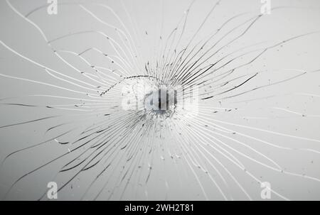 Struttura del vetro incrinata su sfondo grigio. Foto Stock