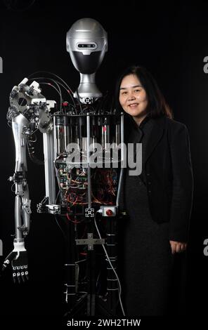 (240207) -- PECHINO, 7 febbraio 2024 (Xinhua) -- Qiao Hong, accademico dell'Accademia cinese delle scienze, posa con un robot umanoide il 31 gennaio 2024. I robot umanoidi "Q Family" sviluppati dal team di ricerca dell'Institute of Automation, Chinese Academy of Sciences, hanno recentemente fatto il loro debutto pubblico a Pechino. Guidato da Qiao Hong, accademico dell'Accademia cinese delle scienze e direttore del laboratorio statale chiave dei sistemi di intelligenza artificiale multimodale, il team di ricerca ha costruito una "grande fabbrica" per la progettazione e l'assemblaggio di robot umanoidi. Diversi prototipi di Q Fam Foto Stock