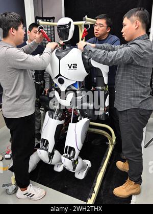 (240207) -- PECHINO, 7 febbraio 2024 (Xinhua) -- i ricercatori regolano un robot umanoide in un laboratorio di IA il 31 gennaio 2024. I robot umanoidi "Q Family" sviluppati dal team di ricerca dell'Institute of Automation, Chinese Academy of Sciences, hanno recentemente fatto il loro debutto pubblico a Pechino. Guidato da Qiao Hong, accademico dell'Accademia cinese delle scienze e direttore del laboratorio statale chiave dei sistemi di intelligenza artificiale multimodale, il team di ricerca ha costruito una "grande fabbrica" per la progettazione e l'assemblaggio di robot umanoidi. Diversi prototipi di robot umanoidi "famiglia Q" hanno ottenuto p Foto Stock