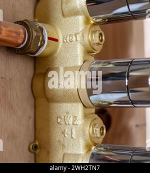 Tubo dell'acqua calda in rame collegato al comando della valvola della doccia da nascondere nella parete. Foto Stock