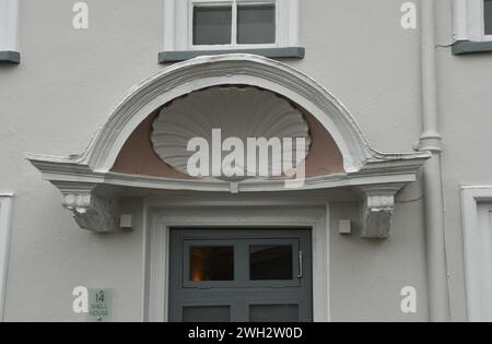 Portico con conchiglie dell'VIII secolo sopra una porta a Topsham, Devon Foto Stock