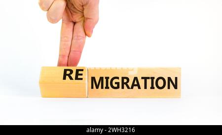 Simbolo di migrazione o di remigrazione. Concetto di Migration Remigration su bellissimi cubi di legno. Splendido sfondo bianco. Mano d'affari. Affari Foto Stock