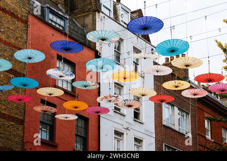 Ombrelli colorati appesi sulla strada di Chinatown a Soho, Londra Foto Stock