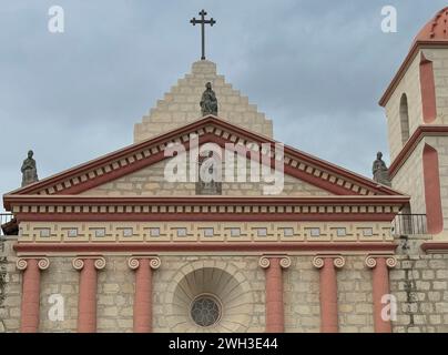 Santa Barbara, CA, Stati Uniti - 18 dicembre 2023: Primo piano del Pediment sulla facciata della Old Mission Church sul cielo blu. Le statue sono di Santa Barbara Foto Stock