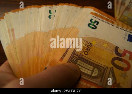 50 banconote in euro in mano a un uomo, primo piano. Foto Stock