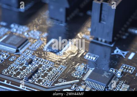 Macro shot dei componenti della scheda madre con chip transistor. Il chipset della scheda madre coordina la comunicazione tra i dispositivi hardware del computer. Foto Stock