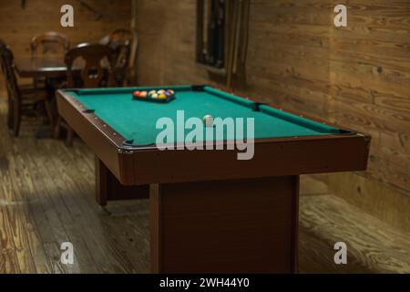 Un tavolo da biliardo in una cabina rustica, tutto pronto per giocare Foto Stock