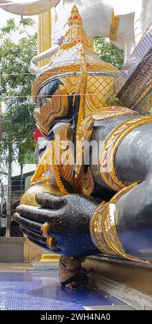 Il carattere mitologico Phra Rahu al tempio buddista con i credenti sotto le sue mani, Thailandia Foto Stock