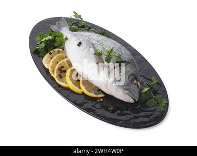Pesce dorado crudo, prezzemolo, fette di limone e grani di pepe isolati su bianco Foto Stock