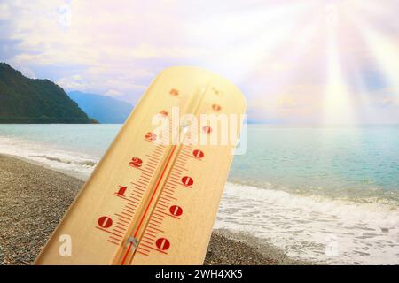 Termometro sulla sabbia in spiaggia durante il sole del giorno estivo Foto Stock