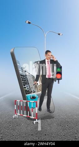 Un uomo d'affari durante una telefonata che cammina mentre porta la valigia per strada con vista sulla città sullo schermo del telefono cellulare. Concetto di viaggio Foto Stock