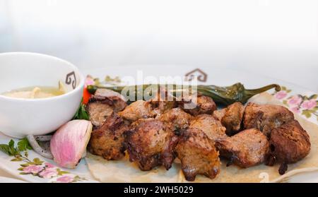 Kebab di manzo arabo con salsa e cipolla su sfondo bianco. Kebab di manzo grigliato sano. Copia spazio Foto Stock