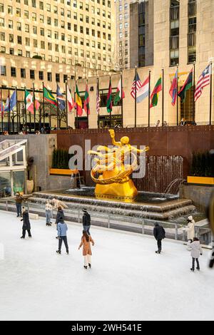 New York City , NY; 19 febbraio 2022: Gente del posto e turisti che si godono il pattinaggio su ghiaccio e la vista dello skyline di Manhattan al Rockefeller Center di New York. Foto Stock