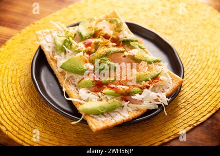 Toast fritti con farina di grano con pelle di maiale sottaceto, panna acida e verdure con salsa calda, in Messico si chiama Chicharron preparado, strada tradizionale Foto Stock