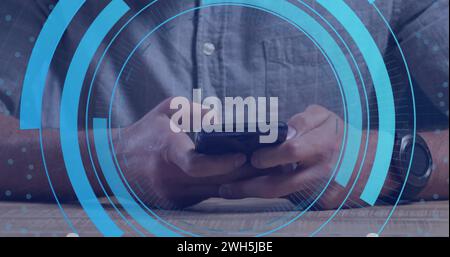 Immagine dei cerchi di elaborazione sulle mani di un uomo caucasico utilizzando lo smartphone Foto Stock