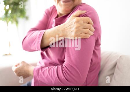 La donna anziana soffre di dolore alle articolazioni della spalla, rigidità della spalla o osteoporosi Foto Stock