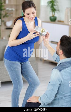 donna incinta si sente sorpresa dopo aver ricevuto il regalo da suo marito Foto Stock