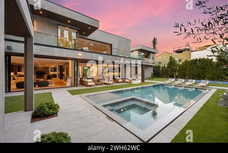 Una casa moderna con una piscina nel mezzo di un ampio cortile Foto Stock