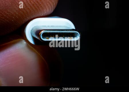 Tecnologia innovativa a portata di mano - una foto macro di primo piano che tiene in mano un elegante connettore USB di tipo C, catturando l'essenza della connettività moderna. Foto Stock