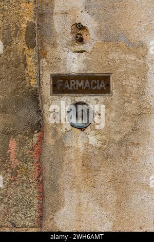 Farmacia in italiano, o Farmacia in inglese vecchio piatto sulla parete in decomposizione, pulsante suoneria, cassetta postale sulla parete, città di Seggiano, Grosseto, Italia, UE Foto Stock