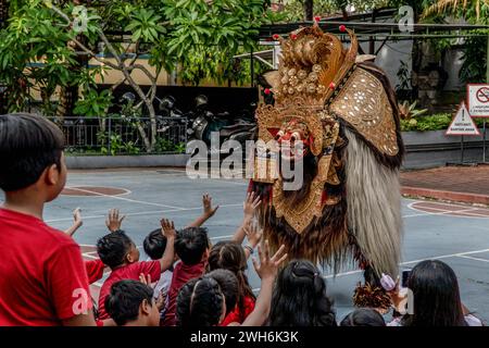 Badung, Indonesia. 7 febbraio 2024. Un Single Barong balinese intrattiene gli studenti alla Widiatmika School di Jimbaran, Badung, Bali, Indonesia, in occasione della celebrazione dell'imminente Capodanno lunare cinese, prevista per il 10 febbraio 2024. Il Capodanno lunare cinese nel 2024 segna l'anno del Drago. (Foto di Dicky Bisinglasi/SOPA Images/Sipa USA) credito: SIPA USA/Alamy Live News Foto Stock