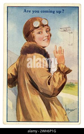Cartolina originale illustrata a colori degli anni '1920 di una giovane donna emancipata, pilota/aviatore o passeggero, che indossa un casco in pelle, una giacca volante rivestita in pelliccia e occhiali di protezione, salutando, in procinto di salire a bordo di un biplano, "Are you coming up". Illustrato da J.L. Biggar. Datato / pubblicato il 12 ottobre 1922 Foto Stock