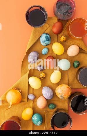 Il processo di tintura delle uova di Pasqua con coloranti naturali, ibisco e curcuma, buccia di cipolla e cavolo rosso, succo di barbabietola, contenitori di vernice e colorato Foto Stock