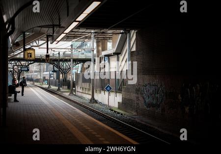 I pendolari aspettano su una piattaforma per il treno ad Amsterdam, Paesi Bassi. Foto Stock