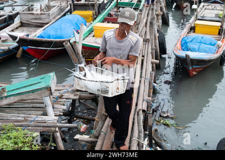 Lampung, Indonesia, 19 maggio 2023: Un pescatore trasporta il pesce catturato in un cesto Foto Stock