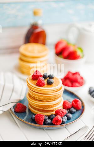 I classici pancake americani fatti in casa con mirtilli, lamponi e fragole. Foto Stock