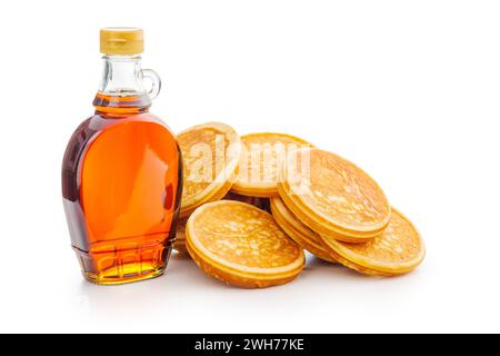 Pancake e sciroppo d'acero in bottiglia isolato sul dorso bianco. Foto Stock