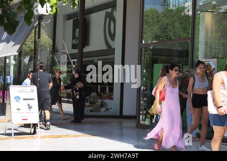 Donna che vende gingilli e braccialetti all'esterno dei negozi Atene Attica Grecia Foto Stock