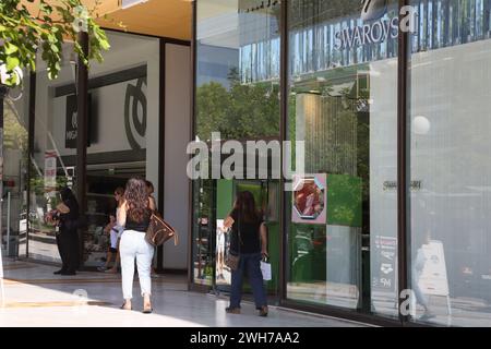 Donna che vende gingilli e braccialetti all'esterno dei negozi Atene Attica Grecia Foto Stock