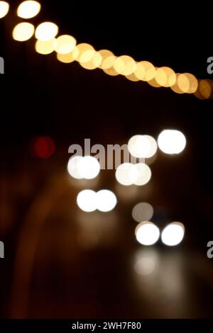 fari di auto che guidano lungo un'autostrada illuminata di notte, immagine concettuale sfocata e sfocata Foto Stock