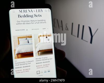Persona che detiene un cellulare con la pagina web della società di design domestica statunitense Serena e Lily Inc. Davanti al logo. Messa a fuoco al centro del display del telefono. Foto Stock