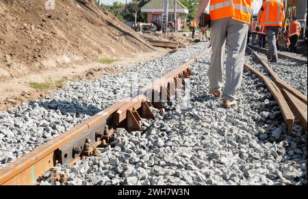 Riparazione ferroviaria. I lavoratori in uniforme stanno cambiando la vecchia linea ferroviaria. Foto Stock