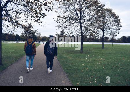 Due ragazzi con zaini in giro per il Regents Park nella città di Londra, Regno Unito, il 22 ottobre 2017 Foto Stock