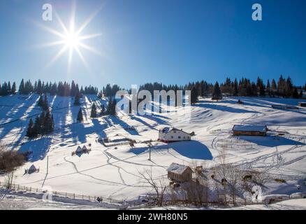 Soleggiata giornata invernale su colline innevate con piste da sci Foto Stock