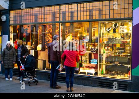 Vetrina per le persone fuori da una vetrina illuminata Foto Stock
