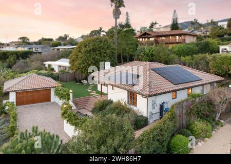 Una casa moderna con un cortile rialzato e tetto coperto da pannelli solari Foto Stock