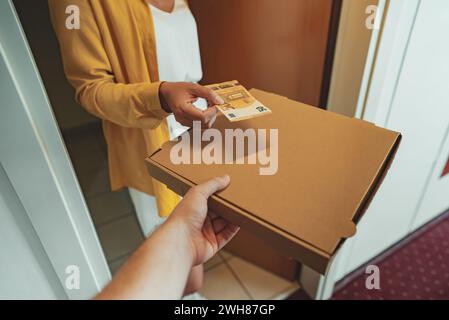 L'uomo consegnare la pizza in scatola e di prendere il pagamento. Foto Stock