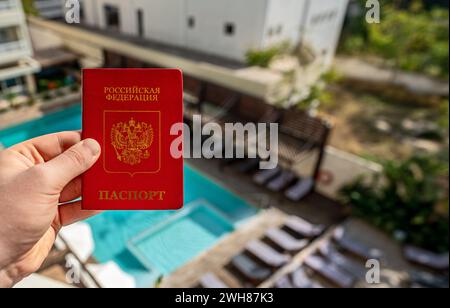 Uomo con passaporto russo sullo sfondo di un hotel di lusso. Foto Stock