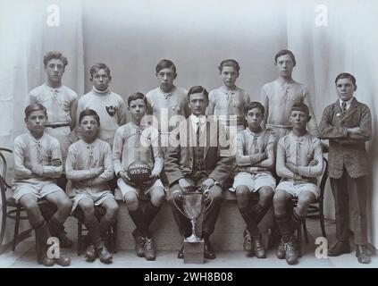 Portsmouth, Hampshire. 1926 – Una fotografia della squadra di calcio della scuola Milton F.C., di Milton, Portsmouth, scattata dopo aver vinto il torneo della "Evening News" Schools Football Cup. La foto mostra i ragazzi nella loro divisa da calcio in posa con il loro insegnante/allenatore e la coppa. Le medaglie a premi che sono state assegnate sono state fissate alle loro magliette. La finale si è giocata tra la Milton School e la Reginald Road School il 1 aprile 1926 al Portsmouth F.C.'s Ground, Fratton Park. Milton ha vinto la partita, due gol a zero. Foto Stock